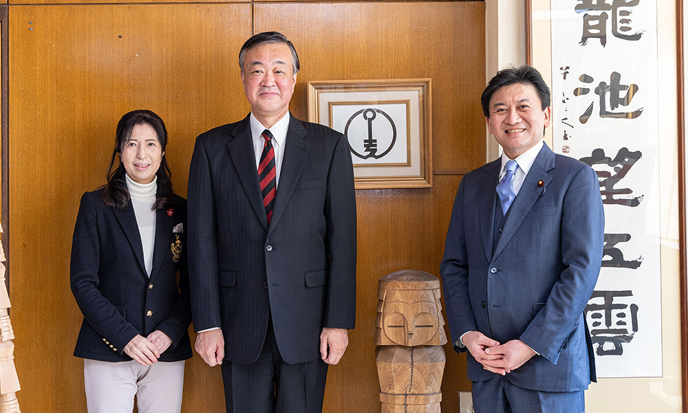 木彫りの人形は網走の民芸品「ニポポ」。網走刑務所の受刑者が手作りで制作している （右）武部 新 衆議院議員、（中央）水谷洋一 網走市長、（左）上野通子 新聞出版局長