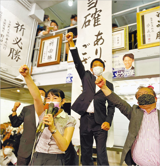 当選確実の報を受け、支援者らとガンバローコールをする齋藤元彦氏(中央)